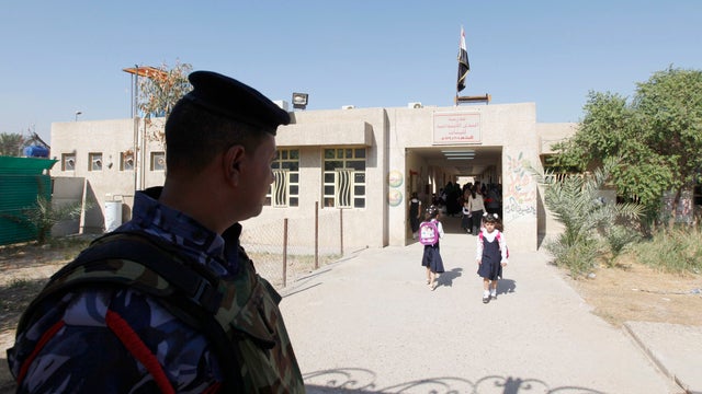 An Iraqi policeman stands guard during the first day of the new school term in Baghdad 