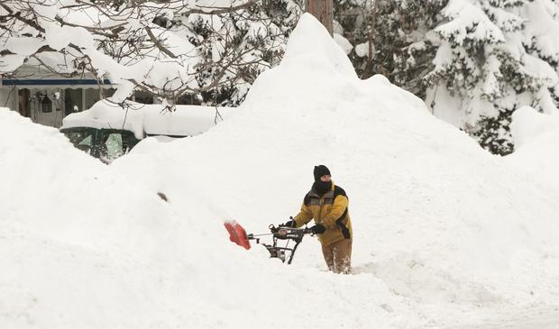 A man clears his driveway of snow following an autumn snowstorm in Buffalo, N.Y., Nov. 20, 2014. 