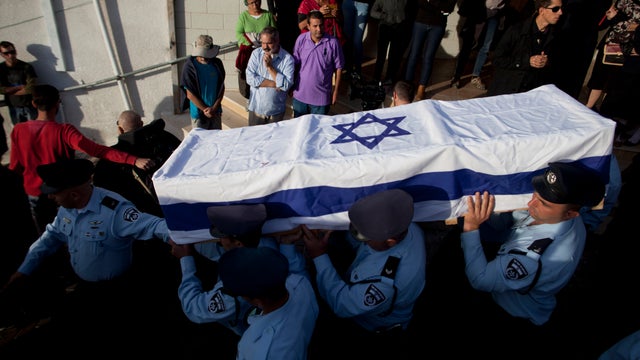 Israeli police officers carry the flag wrapped coffin of Druze Israeli police officer Zidan Sif during his funeral 