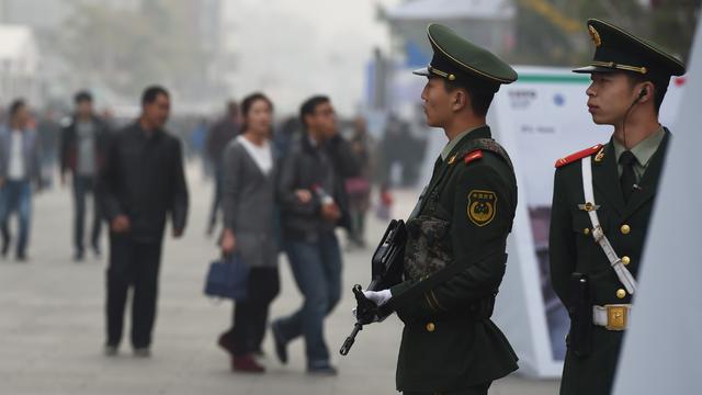 Chinese paramilitary police officers watch over pedestrians in the Wangfujing shopping district in Beijing 