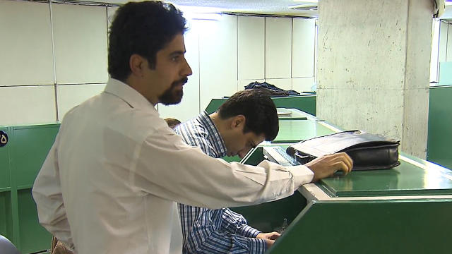 ​Iranian stock trader Mojtaba Shabazi at work on the floor of the Tehran Stock Exchange 