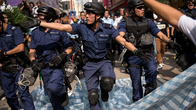 Police march forward as they clear out a pro-democracy protest camp in the Mongkok district of Hong Kong 