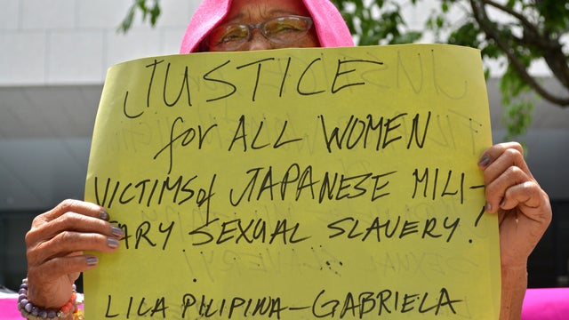 A former "comfort woman" holds up a placard calling for justice during a standing demonstration near the Diet, or parliament, in Tokyo June 2, 2014, to demand that Japan formally atone for forcing women into wartime military brothels. 