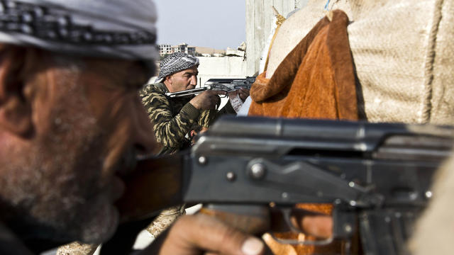 Fighters from the Free Syrian Army, left, and the Kurdish People's Protection Unit (YPG), center, join forces to fight Islamic State of Iraq and Syria militants in Kobani, Syria, Nov. 19, 2014. 