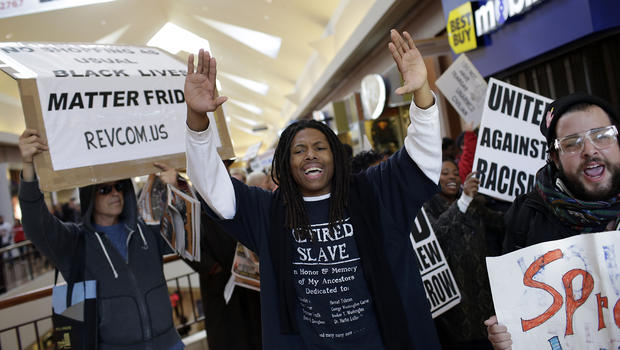 Demonstrators protesting the shooting death of Michael Brown hold signs as they walk through the Saint Louis Galleria mall yelling chants on Black Friday, Nov. 28, 2014, in St. Louis, Missouri. 
