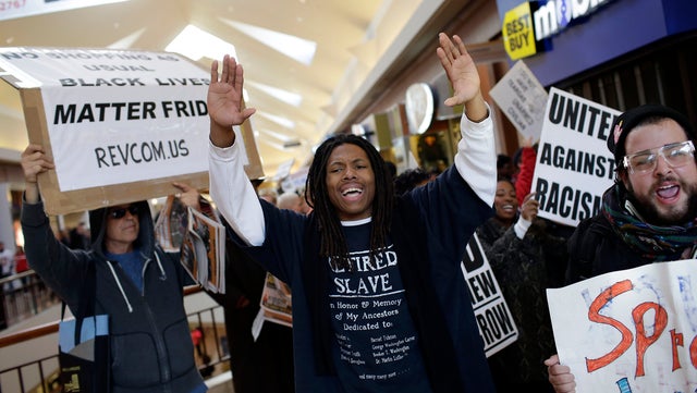 Demonstrators protesting the shooting death of Michael Brown hold signs as they walk through the Saint Louis Galleria mall yelling chants on Black Friday, Nov. 28, 2014, in St. Louis, Missouri.