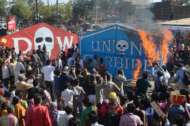 Indian residents and Bhopal gas disaster survivors set alight a Union Carbide banner as they commemorate the 30th anniversary of the disaster in Bhopal Dec. 3, 2014. 