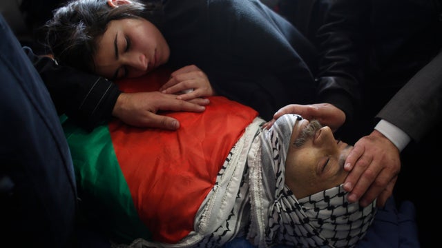 The daughter of Palestinian minister Ziad Abu Ain mourns over his body during his funeral 