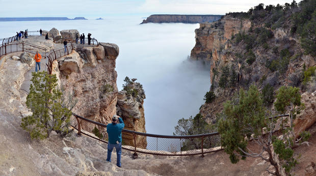 Visitors to Mather Point on the South Rim of Grand Canyon National Park, Ariz., view a rare weather phenomenon - a sea of thick clouds filling the canyon just below the rim, Dec. 11, 2014. 