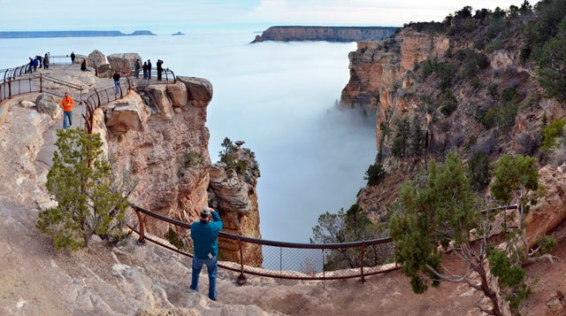 Visitors to Mather Point on the South Rim of Grand Canyon National Park, Ariz., view a rare weather phenomenon - a sea of thick clouds filling the canyon just below the rim, Dec. 11, 2014.