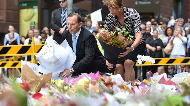 Australian Prime Minister Tony Abbott and his wife Margaret lay wreaths at a makeshift memorial near the site of fatal siege in the heart of Sydney's financial district 