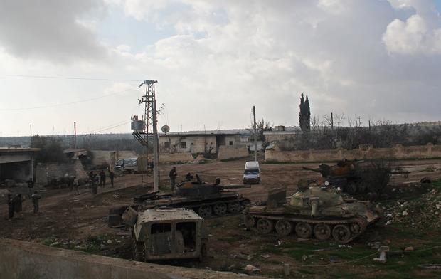 Islamic fighters walk around al-Hamidiyeh base, one of two military posts they took control of from the Syrian Army, Dec, 15, 2014. 