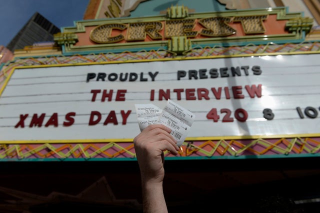 Tickets for the film "The Interview" are seen being held up by theater manager Donald Melancon at Crest Theater in Los Angeles on December 24, 2014