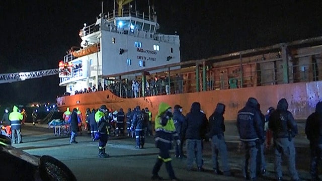 ​Italian police and other officials are seen at the dock in Gallipoli, Italy, where the freighter Blue Sky M was safely docked after being rescued at sea 