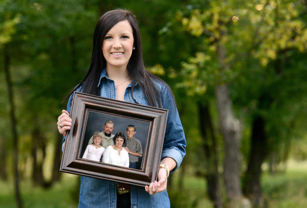 Robin Doan today, holding family photo 