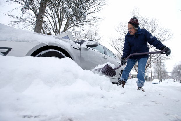 Mike Mindel removes snow from around his car Jan. 6, 2015, in Zionsville, Indiana.