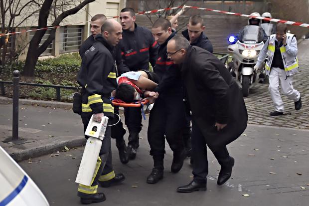 A victim is evacuated on a stretcher, Jan. 7, 2015, after armed gunmen stormed the offices of the French satirical newspaper Charlie Hebdo 