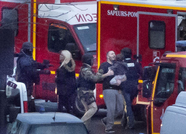 A security officer directs released hostages after police stormed a kosher market to end a hostage situation in Paris Jan. 9, 2015. 