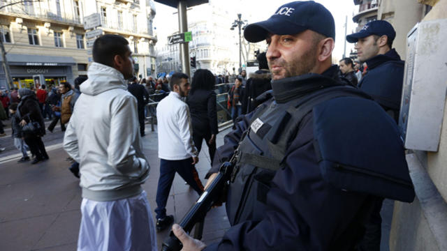 A French intervention police officer looks on as several thousand people gather to pay tribute to the victims following a shooting by gunmen at the offices of the satirical weekly newspaper Charlie Hebdo in Marseille, France, Jan. 10, 2015. 