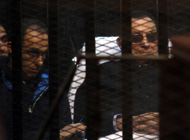 Egypt's former president Hosni Mubarak (R) and his son Gamal sit behind bars during a court hearing on Nov. 29, 2014 in the capital Cairo. 