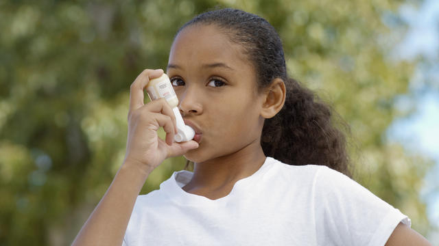 girl using asthma inhaler 