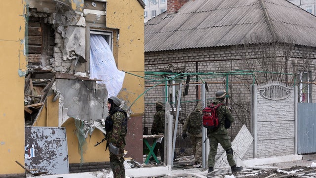 Ukrainian servicemen patrol around a damaged building after shelling in the southern Ukrainian port city of Mariupol Jan. 24, 2015. 