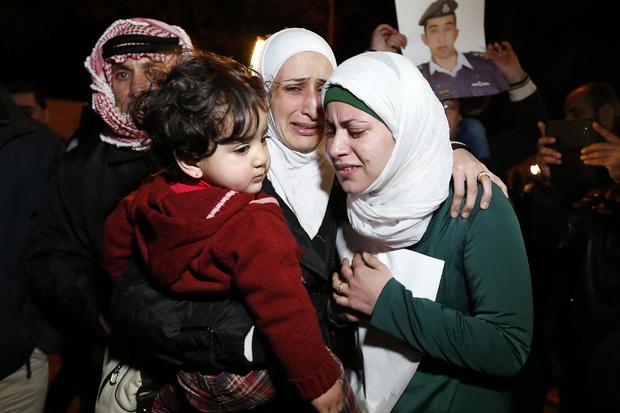 Anwar Tarawneh (R), the wife of ISIS captive Jordanian pilot Lieutenant Muath al-Kasaesbeh, and his sister (C) weep after listening to a statement released by ISIS in front of the Royal Palace in Amman 