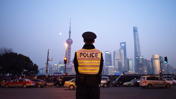 A police officer stands guard to maintain traffic safety at the site of the New Year's Eve stampede in Shanghai Jan. 3, 2015. 