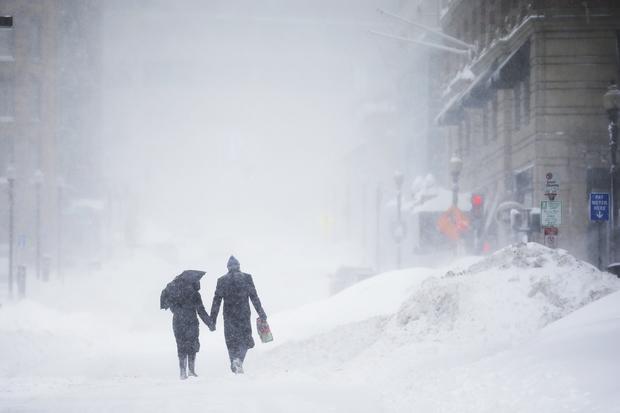 Couple walks hand-in-hand through snow in the Back Bay during a winter blizzard in Boston on February 15, 2015 
