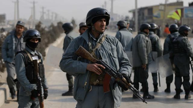 Afghan policemen keep watch at the site of clashes with protesters in Kabul 