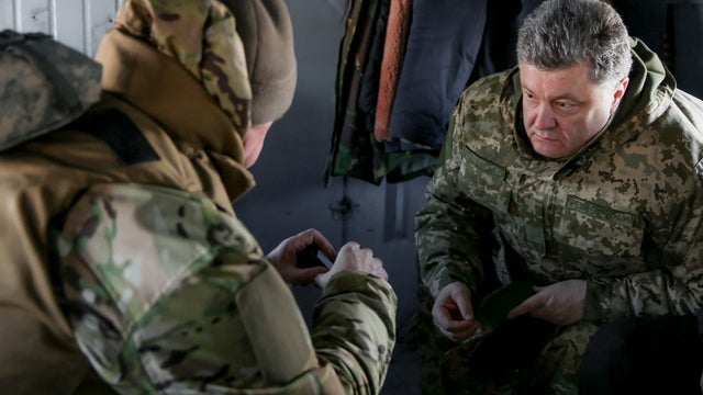 Ukraine's President Petro Poroshenko (R) talks to Chief of Staff of Ukraine's Armed Forces Viktor Muzhenko aboard a helicopter as they travel to Artemivsk 