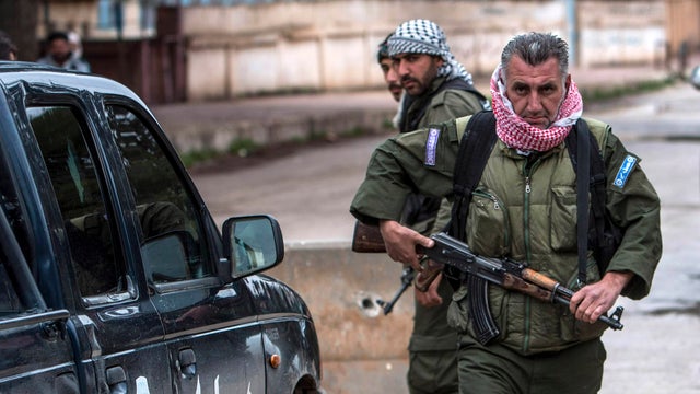 Christian fighters of Sutoro (The Syriac Security Office) carry their weapons as they man a checkpoint in the town of Tel Tamr, Hassakeh province 