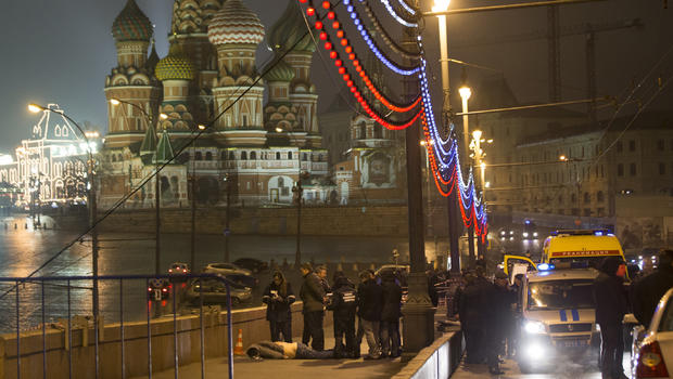 Russian police stand near the body of Boris Nemtsov, a former Russian deputy prime minister and opposition leader, near Red Square with St. Basil Cathedral in the background in Moscow 