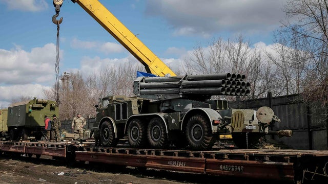 A multiple rocket launcher system belonging to the Ukrainian armed forces is driven onto a wagon of a cargo train at a train station in Artemivsk 