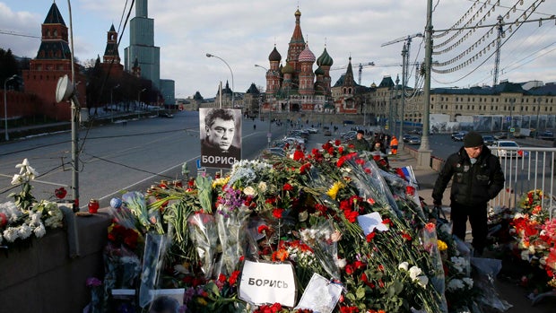 A man walks past flowers at the site where Kremlin critic Boris Nemtsov was murdered at the Great Moskvoretsky Bridge, with St. Basil's Cathedral seen in the background, in central Moscow March 6, 2015. Nemtsov, 55, was shot dead late Feb. 27, 2015, as he 