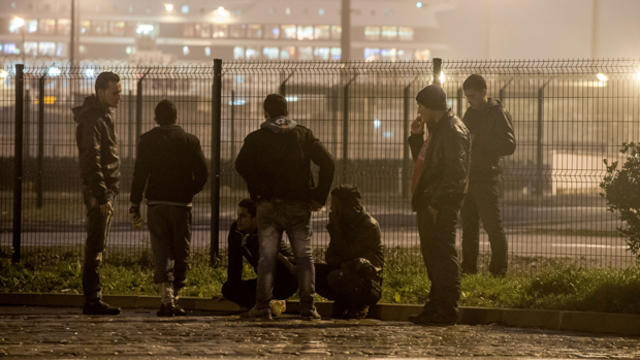 Migrants look at a car ferry in the northeastern French port of Calais Oct. 29, 2014. 