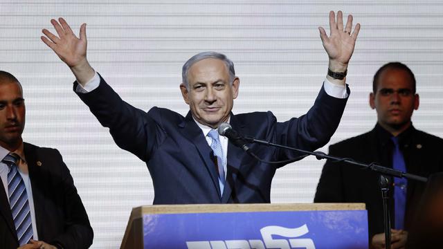 Israeli Prime Minister Benjamin Netanyahu waves to supporters at Likud Party headquarters in Tel Aviv on March 18, 2015 