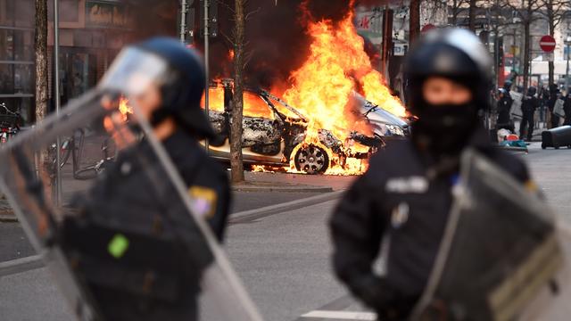 Riot Police form a cordon as a Police car burns on the opening day of the European Central Bank (ECB) in Frankfurt am Main, western Germany, on Mar. 18, 2015.  