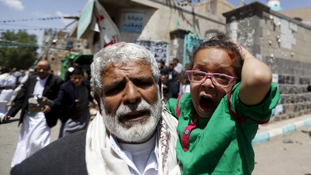 An injured girl reacts as she is carried by a man out of a mosque which was attacked by a suicide bomber in Sanaa, Yemen, March 20, 2015. 