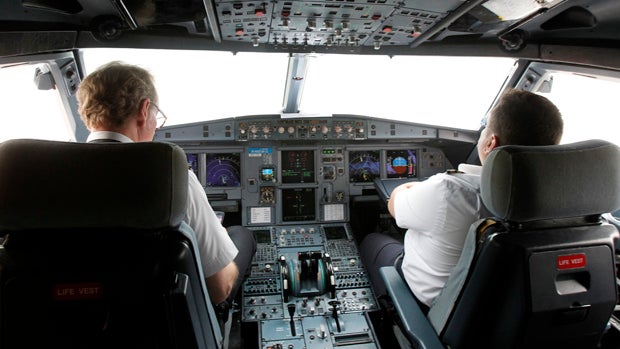 Pilots sit at the cockpit of a VietJet A320 airplane before departure for Bangkok in this Sept. 25, 2013, file photo. 