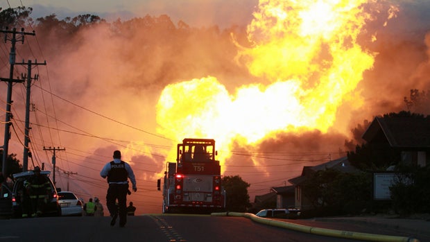 A law enforcement official runs toward a massive fire in a residential neighborhood Sept. 9, 2010, in San Bruno, California. 