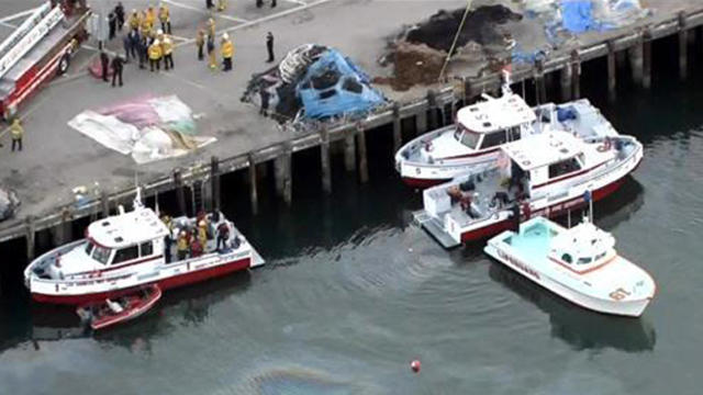 ​Crews work the scene after a car carrying four people went into Los Angeles harbor April 9, 2015. 