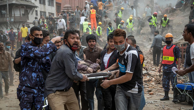 Emergency rescue workers carry a victim on a stretcher after Dharahara Tower collapsed from an earthquake April 25, 2015, in Kathmandu, Nepal. 