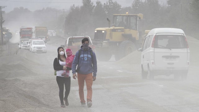Residents wearing surgical masks to protect themselves against ash from Calbuco volcano, walk in a street in Ensenada, Chile 