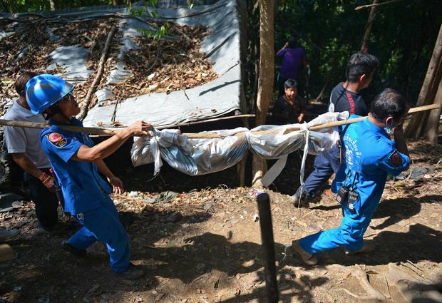 Rescue workers carry a body uncovered at the site of a mass grave at an abandoned jungle camp in the Sadao district of Thailand's southern Songkhla province bordering Malaysia 