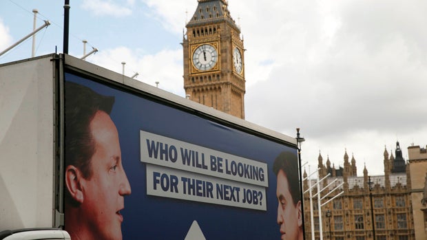 An advertising van with images of Britain's Prime Minister David Cameron and Ed Miliband, leader of the opposition Labour Party, drives around Parliament Square in London May 7, 2015. 