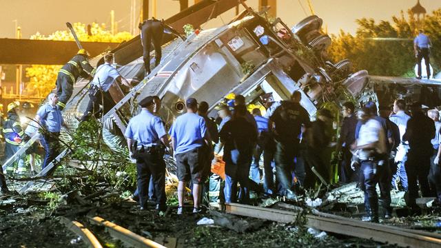 Rescue workers climb into the wreckage of a crashed Amtrak train in Philadelphia 