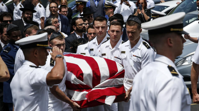 Midshipmen from the U.S. Naval Academy carry Midshipman Justin Zemser's coffin to a waiting car after his funeral May 15, 2015, in Hewlett, New York. 