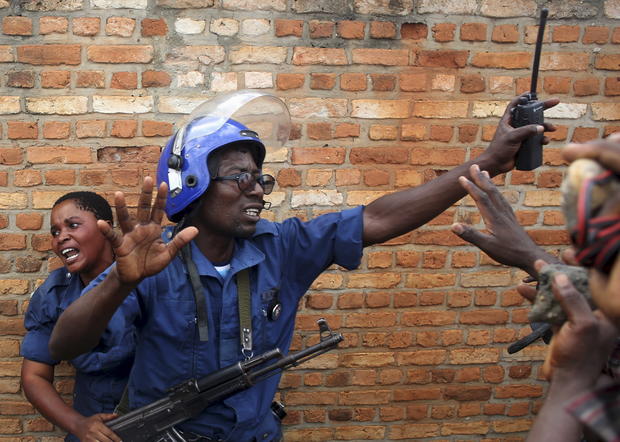 A policeman tries to protect a female police officer accused of shooting a protester in the Buterere neighborhood of Bujumbura 
