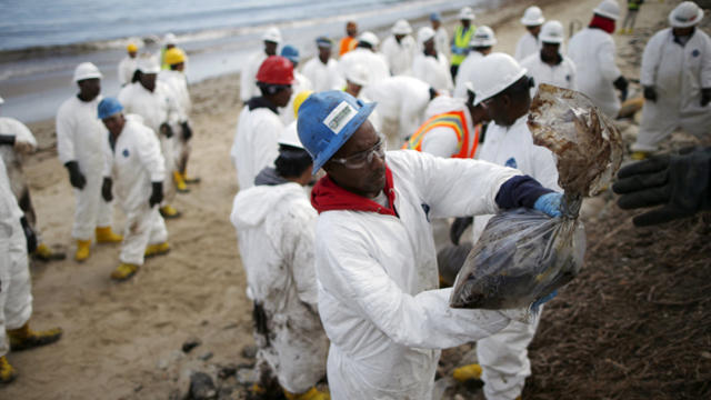 Workers clean up an oil slick along the coast of Refugio State Beach in Goleta, California, May 21, 2015. 